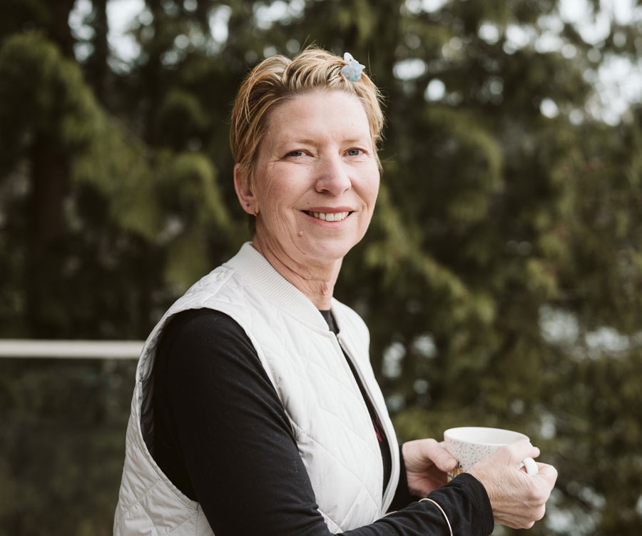 A portrait of a woman with short blonde hair looking at the camera